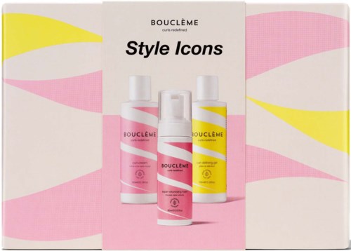 Een doos met haarstylingproducten in roze, geel en witte flessen, labeled 'Style Icons' door Boucléme.