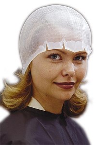 Eine Frau trägt eine weiße Mütze und dunkle Kleidung, mit braunem Haar und leichtem Lächeln.