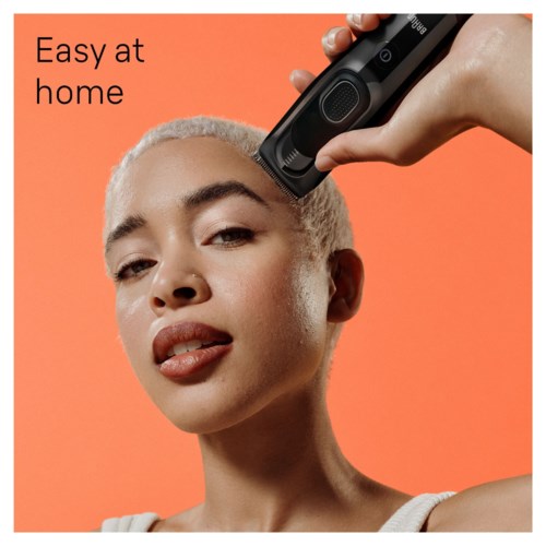 A woman uses a hair clipper on her head with an orange background, and the words "Easy at home" are in the top left.