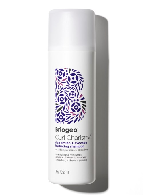 Een witte shampoo fles met een paarse bloemenlogo, genaamd Briogeo Curl Charisma, en vermeldt hydrateren met rijst amino en avocado.