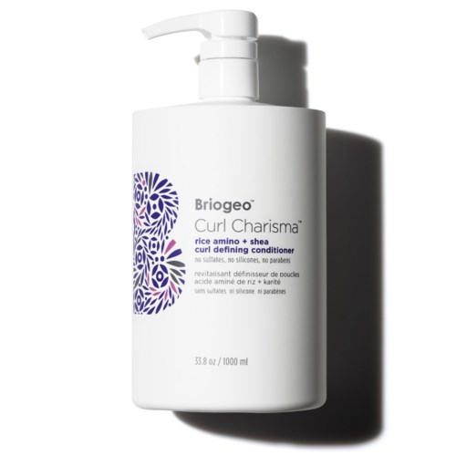 En vit flaska med pump, märkt Brigeo Curl Charisma, för balsam för lockdefiniering. Den har lila och svart text.
