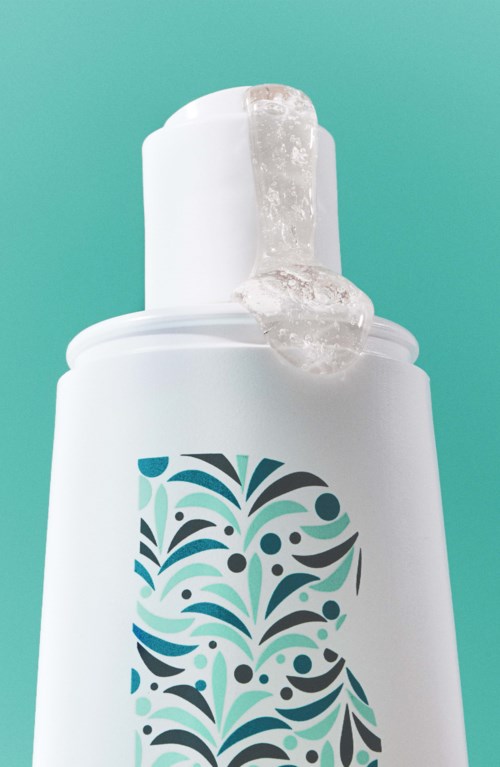 A white bottle with a blue and black decorative design, and gel coming out of the top.
