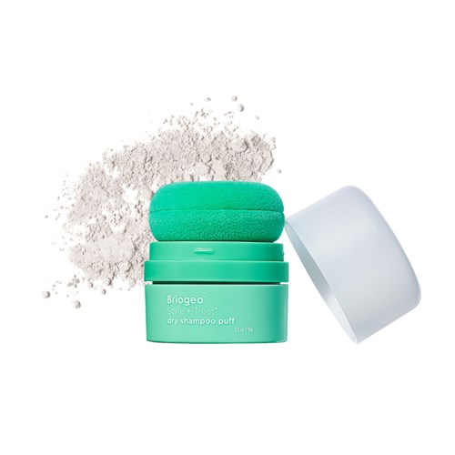Een turquoise container met droogshampoo, wit poeder gemorst en deksel open.