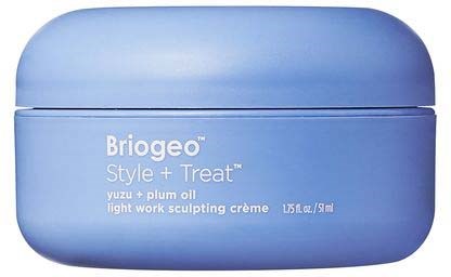 Ein blauer Behälter mit der Aufschrift 'Briogeo Style + Treat', enthält Yuzu- und Pflaumenöl für Styling und leichte Modellierung.