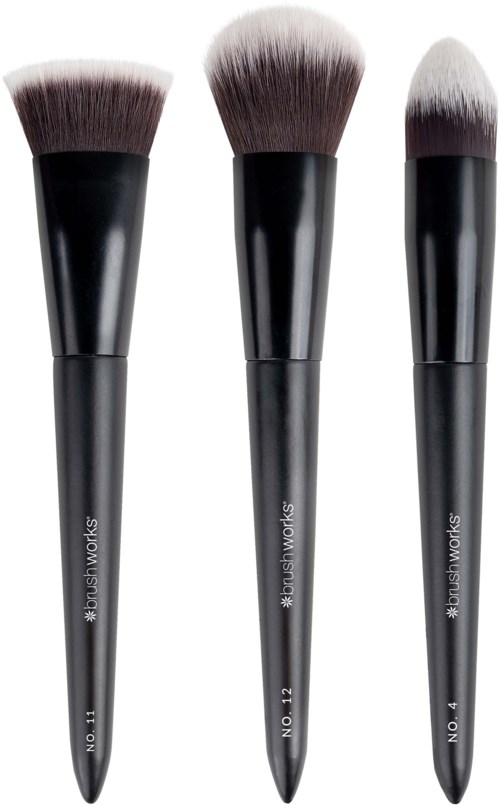 Three makeup brushes with black handles and white bristles, varying in size and shape.