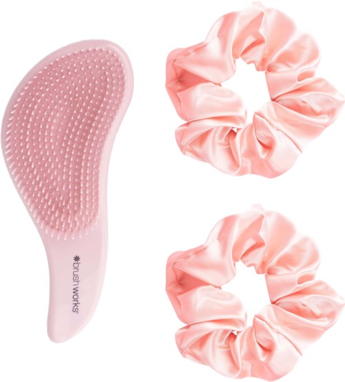 Pinkki päänahkaharja, jossa on pehmeitä harjaksia ja kaksi vaaleanpunaista satiinirusetta.