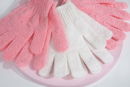 Soft pink and white gloves arranged on a pink surface.