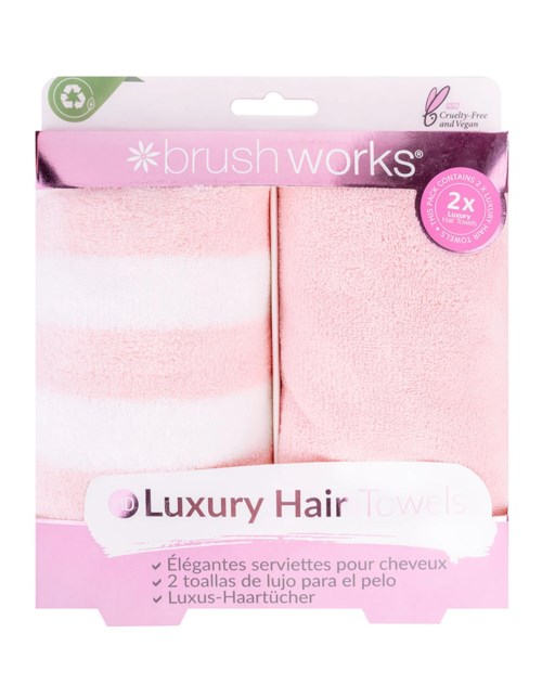 Valkoiset ja vaaleanpunaiset luksushiuskahiushanskat pakkauksessa, merkinnällä 'brush works' ja 'Luxury Hair Towels', vegaanisia ja cruelty-free.