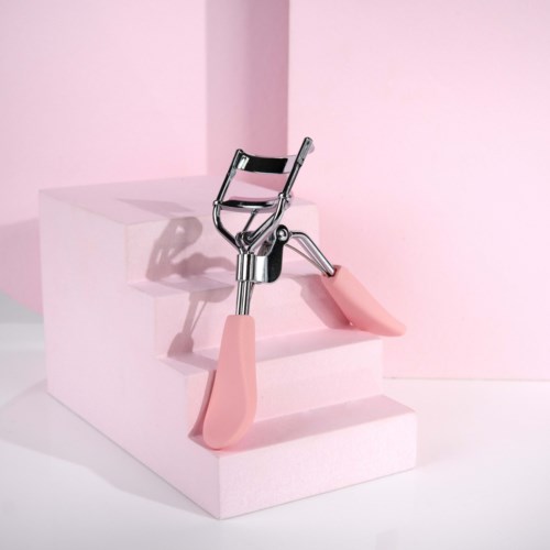 En rullskridsko är vänd upp och ner på rosa steg mot en rosa bakgrund.