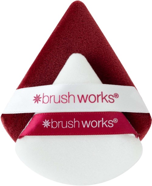 A red, white, and pink makeup sponge with the words 'brush works' on a band around it.
