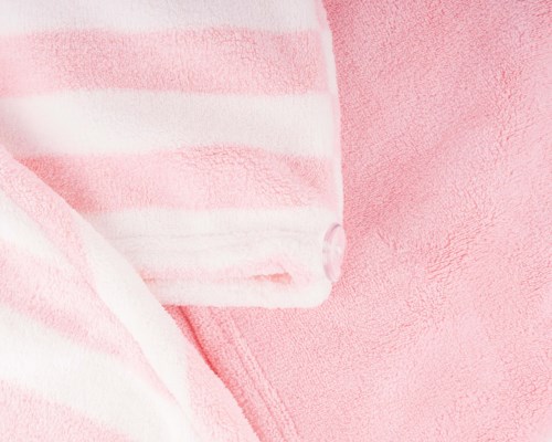 nærbilde av rosa og hvit stripete stoff og en rosa teksturert overflate.