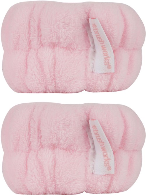Två rosa fluffiga tofflor med vita etiketter som säger 'SOLOMON KIDS'.
