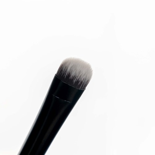 A makeup brush with black handle and white bristles on a white background.