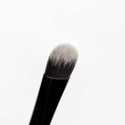 A makeup brush with black handle and white bristles against a white background.
