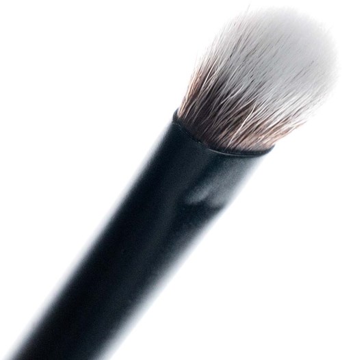 Close-up of a makeup brush with black handle and white bristles.