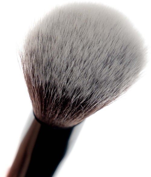 A makeup brush with soft, dense bristles and a glossy handle, used for applying powder or blush.