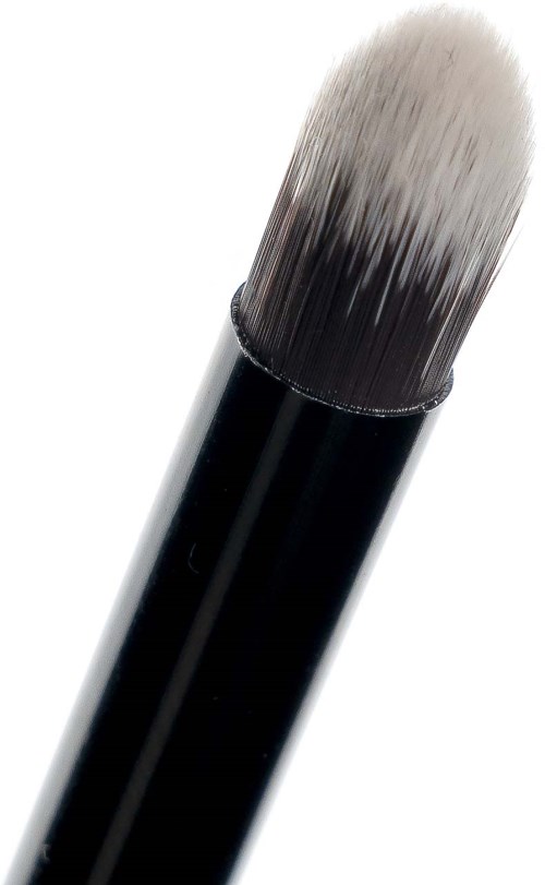 En makeupborste med svart handtag och mjuka, vita till mörka borstspetsar.
