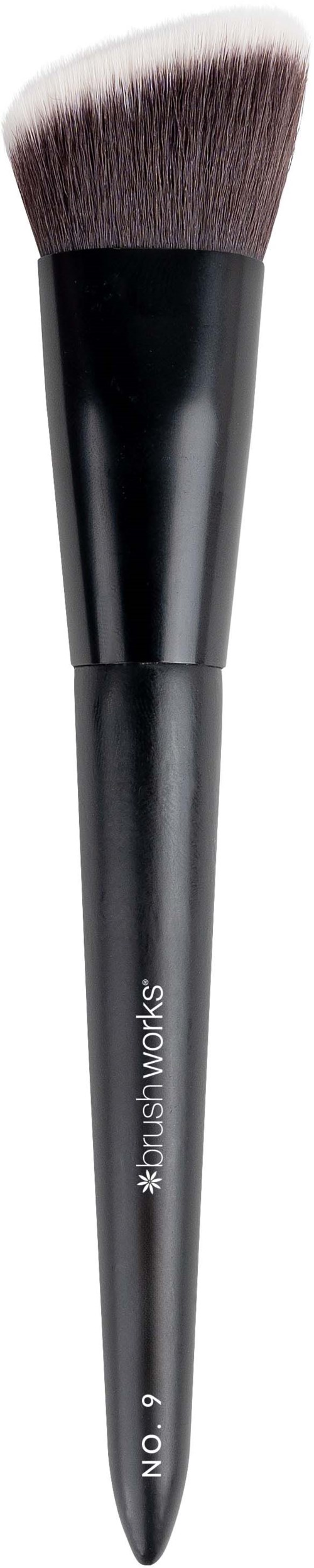 A makeup brush with black handle and soft, rounded bristles. The handle has the words 'style & works' and 'NO' written on it.