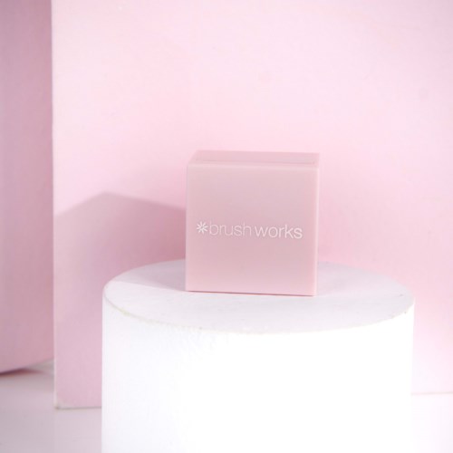 A pink box labeled "brush works" on a white circular platform with a pink background.