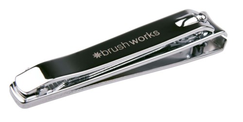 En liten, blank metallklämma med orden 'brush works' på.