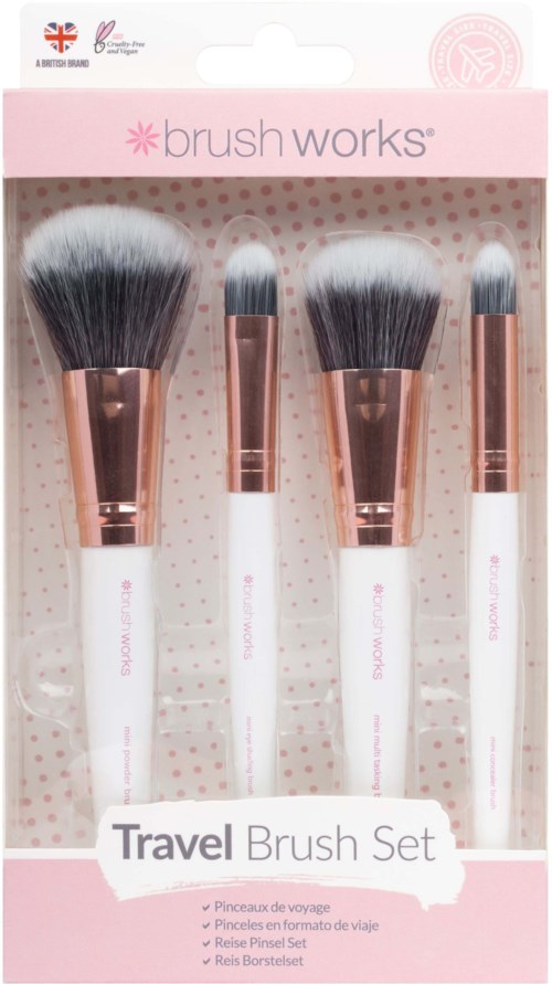 Four makeup brushes with white handles and silver ferrules are in pink packaging labeled 'Travel Brush Set.'