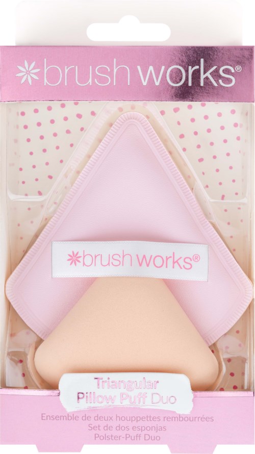 Et rosa triangelpute og en beige pute med matchende deksler i en pakke merket 'brush works' for skjønnhetsbruk.