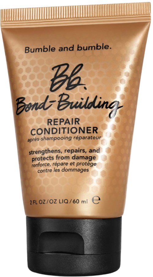 Eine goldene Flasche von Bumble and Bumble Bond Building Repair Conditioner mit schwarzem Deckel.