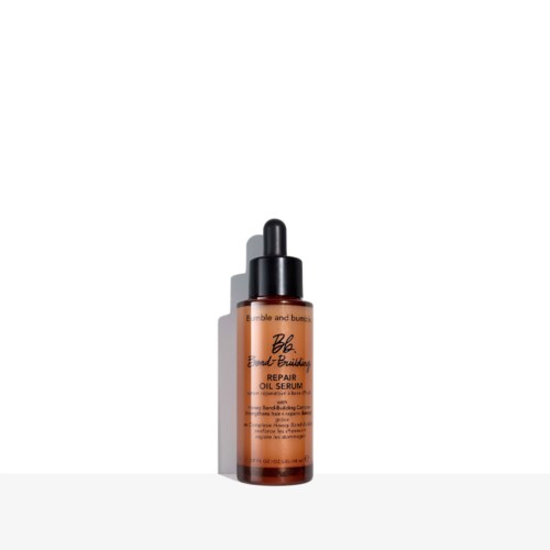 Eine kleine orange Flasche mit schwarzem Tropfer, etikettiert 'Repair Oil Serum' von Bond Braided.