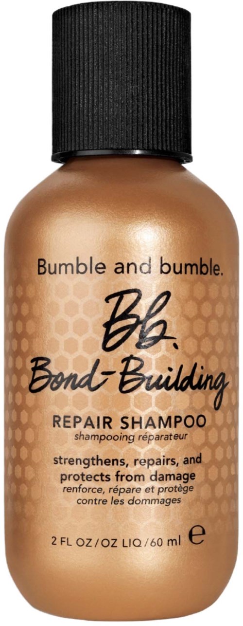 Kleine braune Flasche mit schwarzem Deckel, beschriftet Bond-Building Repair Shampoo zum Stärken und Reparieren der Haare.