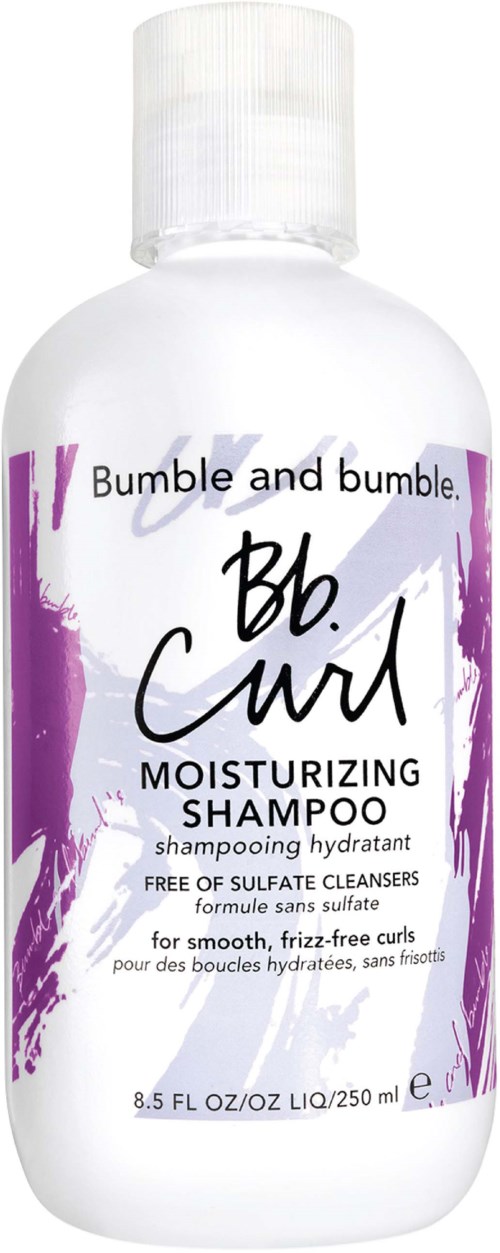 A white bottle of Bumble and bumble. Be. Curl moisturizing shampoo with purple and black text and splash design.