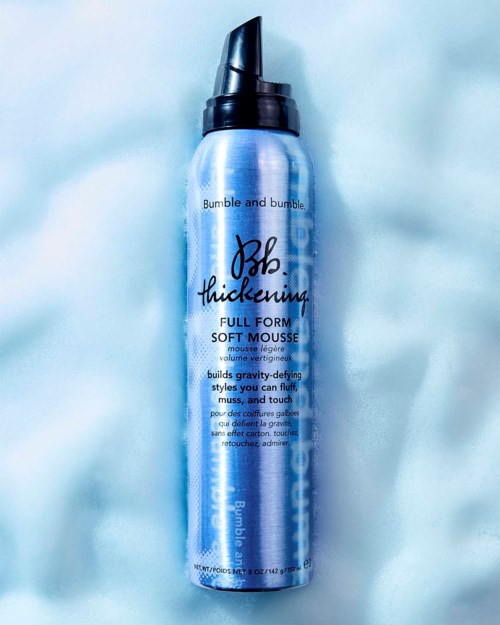 Eine blaue Dose Bumble and Bumble Vollform Weiche Schaumfestiger auf hellblauer Oberfläche.