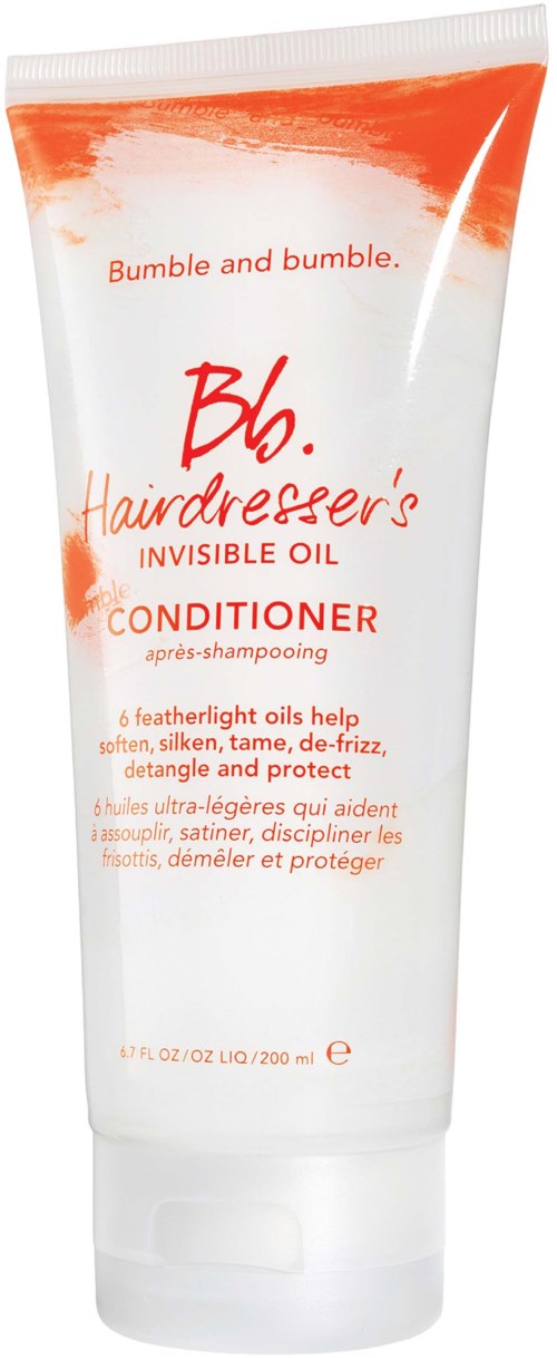 Eine weiße Tube mit orange und roter Schrift, bezeichnet als Haarspülung mit federleichten Ölen, hilft, Haare zu erweichen und zu schützen.