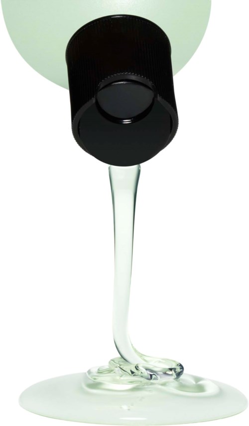 Eine schwarze Flasche mit grünlicher Flüssigkeit, die ausläuft und am Boden spritzt.
