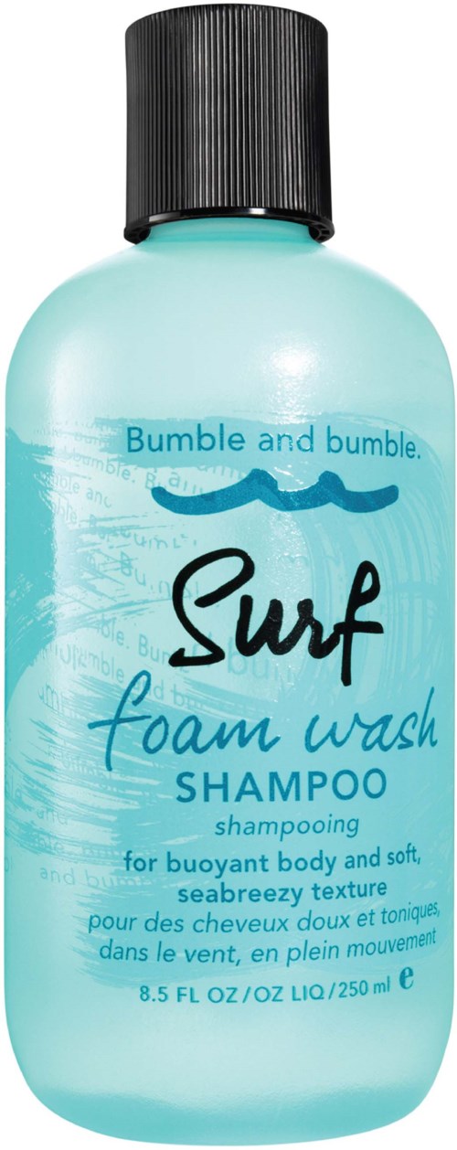 Eine Flasche Bumble and bumble Surf Schaumwaschshampoo, hellblau mit schwarzem Deckel und welligem Textdesign.