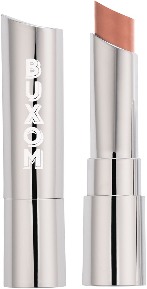 A silver lipstick tube with the word 'BUXOM' on it, and the lipstick partially out, showing a light brown shade.