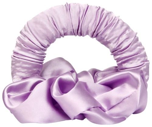 A purple satin scrunchie with a large bow attached, used to tie hair.