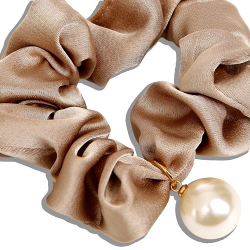 A beige silky scrunchie with a large pearl charm attached.
