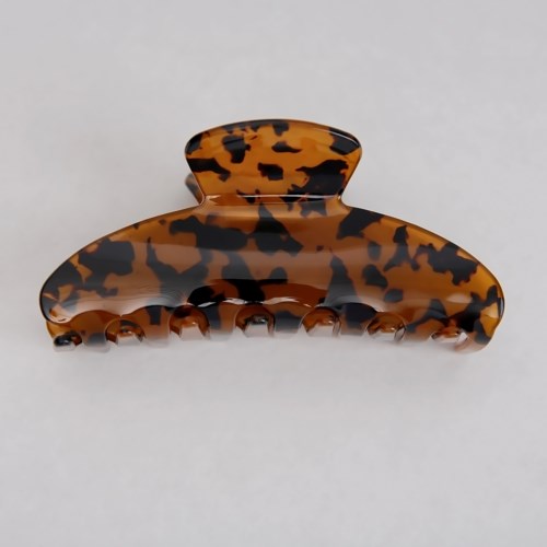A large, brown and black spotted hair clip with multiple teeth for holding hair back.