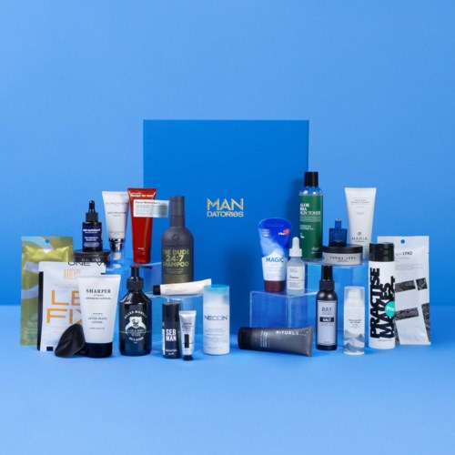 Olika hudvårds- och groomingprodukter är arrangerade framför en blå låda märkt "MAN DATIONS".