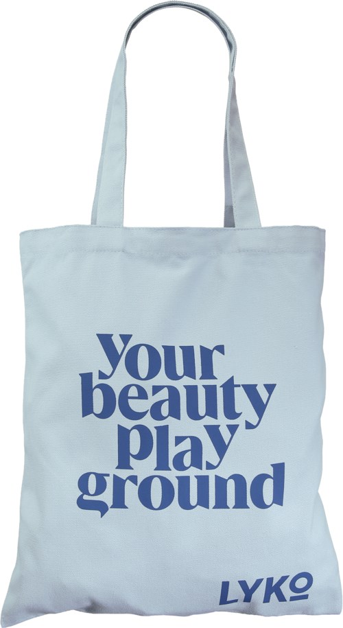 A white tote bag with blue text saying "Your beauty playground" and a small logo at the bottom.