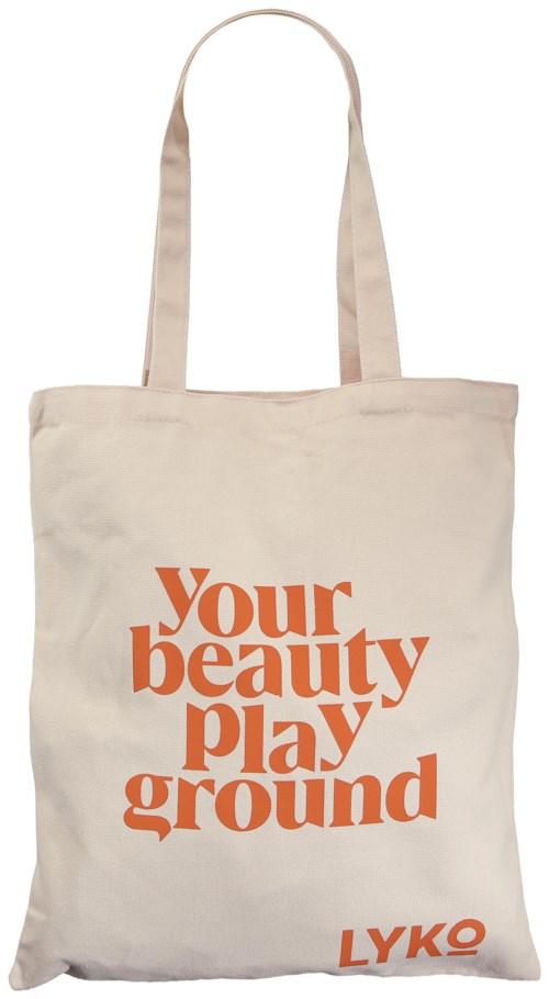 A cream-colored tote bag with orange text saying "Your beauty play ground" and the brand LYKO.