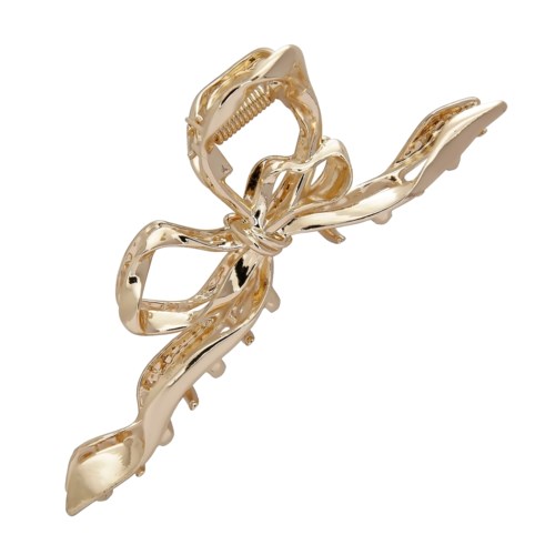 A large, gold-colored hair clip shaped like a bow with shiny surfaces.