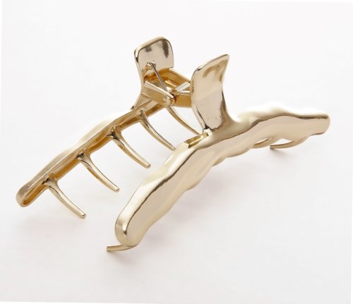Een gouden haarspeld in klauwvorm met meerdere tanden.