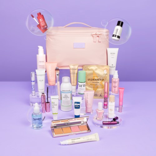 Een roze tas en verschillende huidverzorgings- en make-upproducten gerangschikt voor een paarse achtergrond.