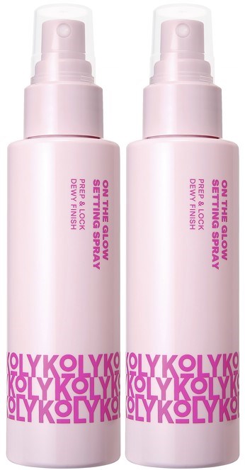 Zwei rosa Sprühflaschen mit pinken Beschriftungen, vermutlich Hautpflege- oder Kosmetikprodukte, stehen aufrecht.