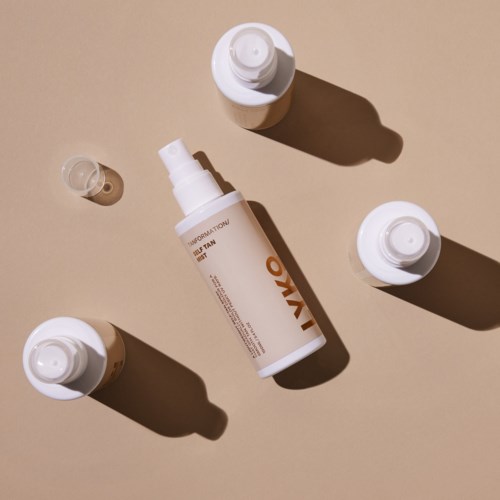 A spray bottle with two smaller bottles and a tiny container on a beige background.