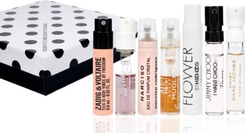 Små parfym- eller body spray-flaskor placerade framför en svartvit prickig låda.