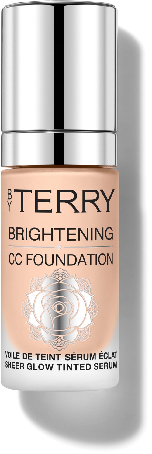 A bottle of BY TERRY Brightening CC Foundation with a shiny silver cap and peach-colored liquid inside.