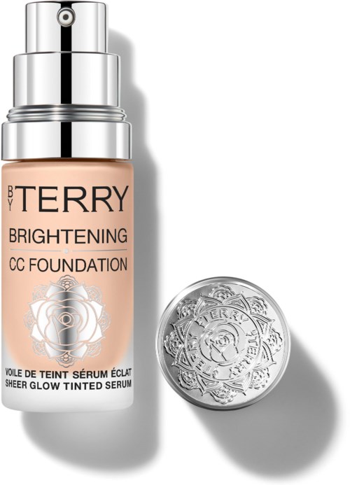 A bottle of BB Terry Brightening CC Foundation with a silver cap and a round embossed container beside it.