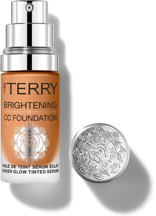A bottle of BB Terry Brightening CC Foundation with a silver pump and a round silver container beside it.